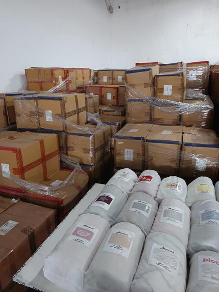 Alfombras enrolladas y cajas del stock en el almacén